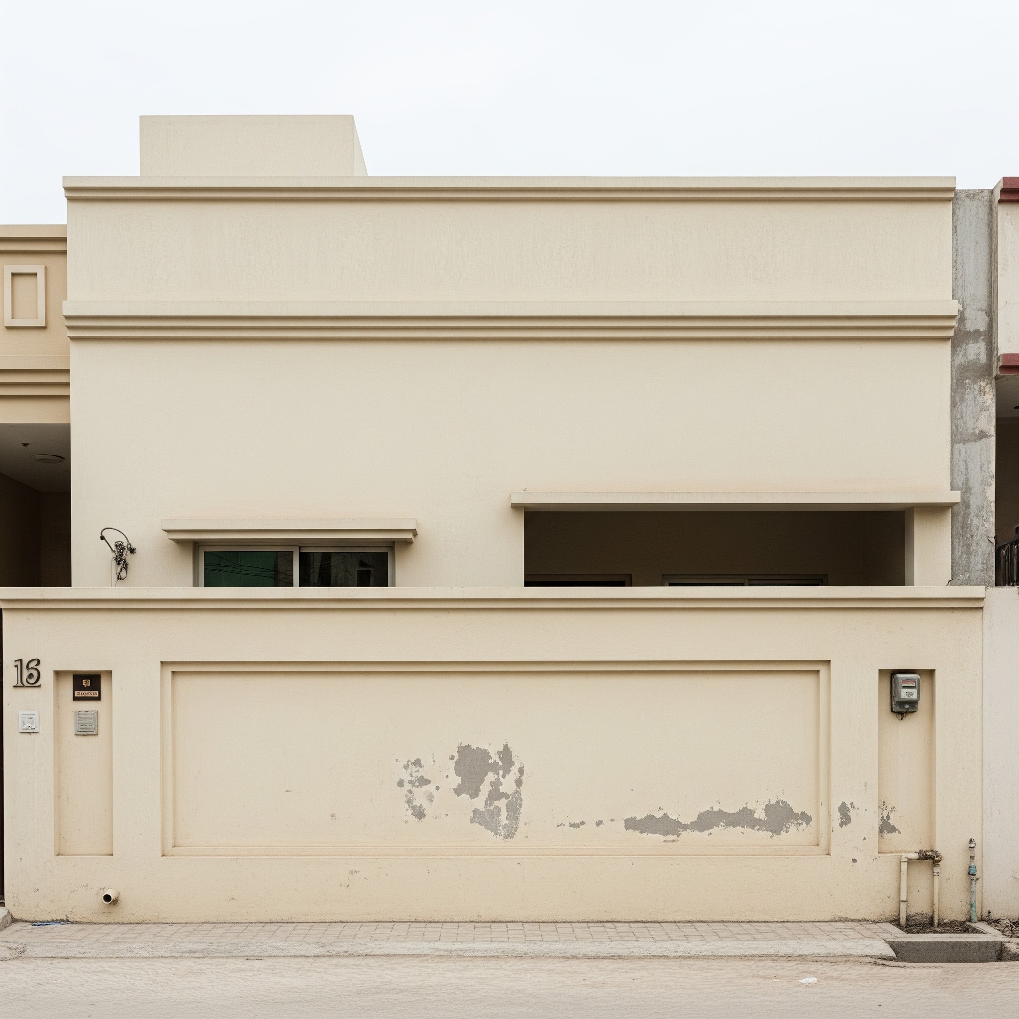 Before facade enhancement: A plain building entrance in Karachi, lacking architectural detail.